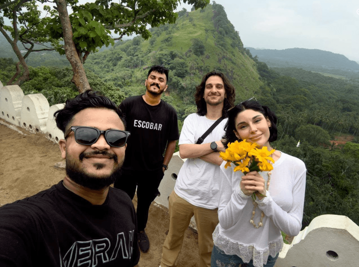 Guests holding traditional yellow flowers at a scenic temple viewpoint